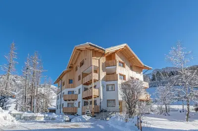 a building in the snow with snow covered trees at Residence Lersc in Badia
