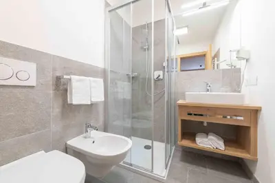 a bathroom with a shower and a toilet and a sink at Residence Lersc in Badia
