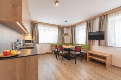 a kitchen and dining room with a table and chairs at Residence Lersc in Badia