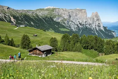 a group of people walking on a hill near a cabin at Hotel Garni Savoy - new opening in Castelrotto