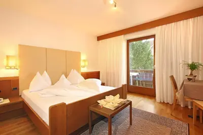 a hotel room with a bed and a table at Hotel Garni Savoy - new opening in Castelrotto
