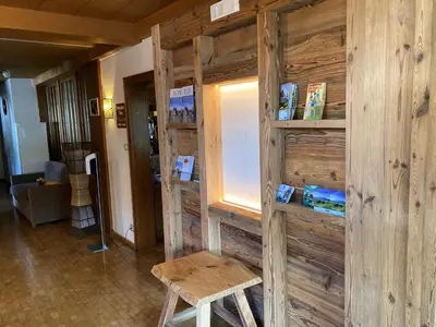 a room with a wooden wall with a table and a stool at Hotel Garni Savoy - new opening in Castelrotto