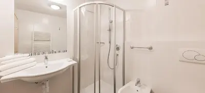 a white bathroom with a sink and a shower at Parkhotel Plauserhof in Plaus