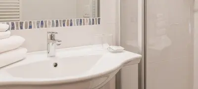 a white bathroom with a sink and a shower at Parkhotel Plauserhof in Plaus