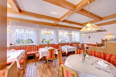 a restaurant with white tables and chairs and windows at Parkhotel Plauserhof in Plaus