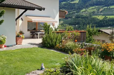 a garden with a view of a house at Sonnenhof in Rifiano
