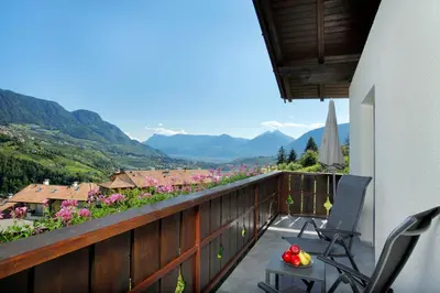 a balcony with chairs and a view of mountains at Sonnenhof in Rifiano