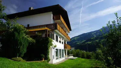 a building on a hill with a view of a mountain at Pension Thalerhof in Rifiano