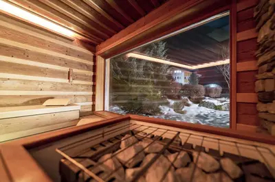 an inside view of a sauna with a large window at Hotel Gran Paradis in Campitello di Fassa