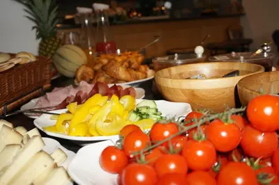 a table topped with plates of food with tomatoes and other foods at Gasthaus Jaufenblick in San Martino