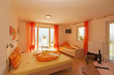 a living room with a bed and a couch and a table at Gasthaus Jaufenblick in San Martino