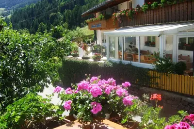 a house with pink flowers in front of it at Gasthaus Jaufenblick in San Martino