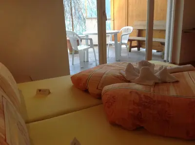 a bed in a room with a table and chairs at Gasthaus Jaufenblick in San Martino