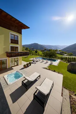 a patio with lounge chairs and a swimming pool at Residence Schiestlhof in Naz-Sciaves