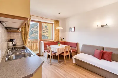 a kitchen and a living room with a couch and a table at Residence Schiestlhof in Naz-Sciaves