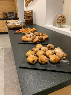 a table with three trays of food on it at Hotel Chalet Alaska in Pozza di Fassa