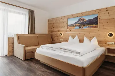 a hotel room with a bed and a couch at Pension Sonnenhof in Maranza
