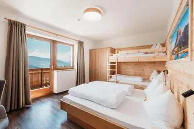 a bedroom with two beds and a large window at Pension Sonnenhof in Maranza