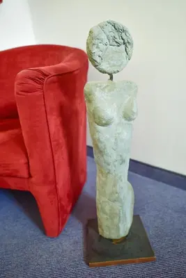 a statue sitting next to a red couch at Pension Martha in Postal