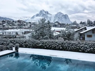 a resort swimming pool with mountains in the background at Hotel Villa Kastelruth in Castelrotto