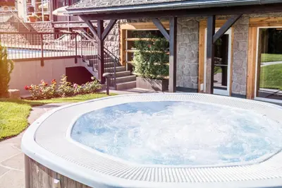 a hot tub in front of a house at Hotel Villa Kastelruth in Castelrotto