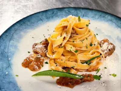 a blue plate with pasta on a table at Albergo Bucaneve in Malosco