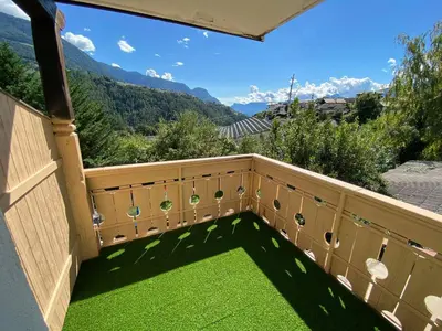 a balcony with green grass and mountains in the background at Laimerhof in Rifiano