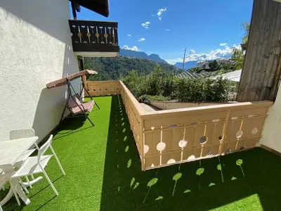 a balcony with a table and chairs on the grass at Laimerhof in Rifiano