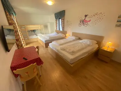 a bedroom with two beds and a table and a table and chairs at Laimerhof in Rifiano