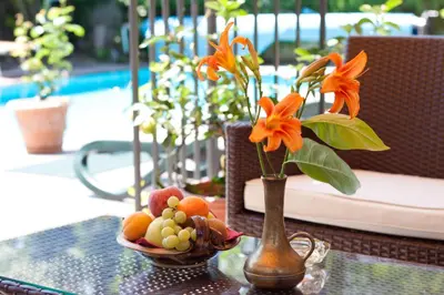 a vase with orange flowers and fruit on a table at Hotel Pension Sonnegg in Saltusio