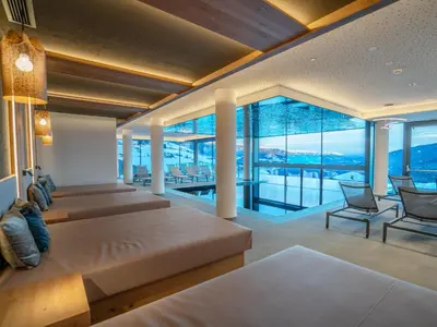 a bedroom with two beds and a large window at Hotel Purvita - Ski In Ski Out - Infinity Pool in Maranza