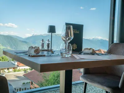 a table with a wine glass sitting on top of it at Hotel Purvita - Ski In Ski Out - Infinity Pool in Maranza