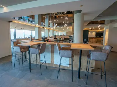 a bar in a restaurant with chairs and tables at Hotel Purvita - Ski In Ski Out - Infinity Pool in Maranza