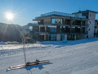 a building in the snow with skis in the snow at Hotel Purvita - Ski In Ski Out - Infinity Pool in Maranza