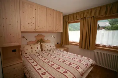 a bedroom with a large bed in a room at Appartamenti Albert in Canazei