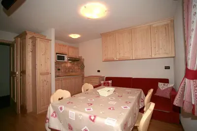 a kitchen with a table and chairs and a kitchen with a kitchen at Appartamenti Albert in Canazei