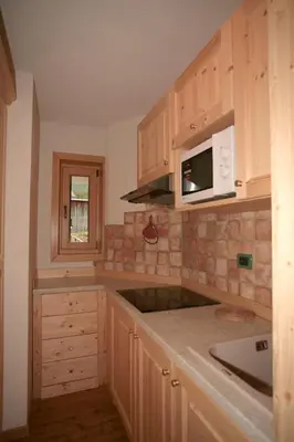 a kitchen with a sink and a microwave at Appartamenti Albert in Canazei