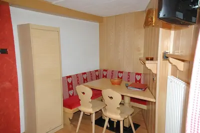a small kitchen with a table and two chairs at Appartamenti Albert in Canazei