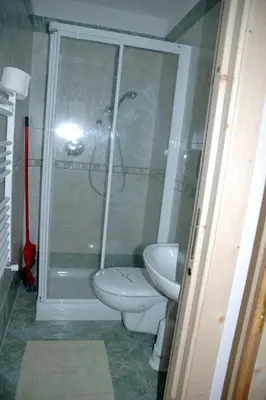 a bathroom with a shower and a toilet and a sink at Appartamenti Albert in Canazei