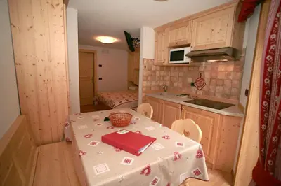 a kitchen with a table with a table cloth on it at Appartamenti Albert in Canazei