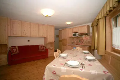a living room with a table with a white table cloth at Appartamenti Albert in Canazei