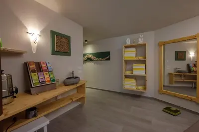 a room with a mirror and a shelf with books at Gasthof Löwen in Nova Levante