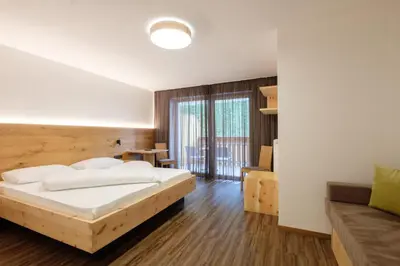 a bedroom with a bed and a couch at Gasthof Löwen in Nova Levante
