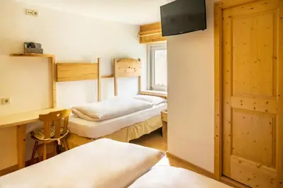 a room with two beds and a window at Villa Insam in Selva di Val Gardena