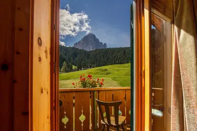 a balcony with a chair and a view of a mountain at Villa Insam in Selva di Val Gardena