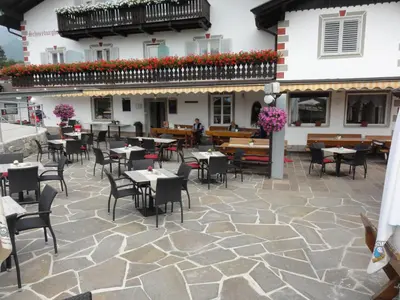 a patio of a restaurant with tables and chairs at Garni Schneeburghof in Tirolo