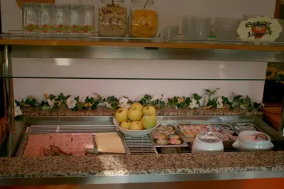 a buffet line with plates of food and a bowl of fruit at Garni Schneeburghof in Tirolo