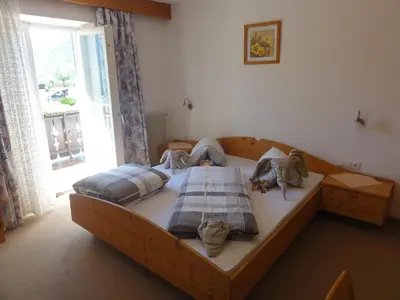 a bedroom with a wooden bed with cats on it at Garni Schneeburghof in Tirolo