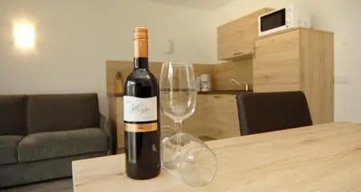 a bottle of wine sitting on a table with a wine glass at Appartment Charly in Siusi