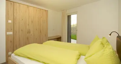 a bedroom with a bed with yellow sheets and a window at Appartment Charly in Siusi